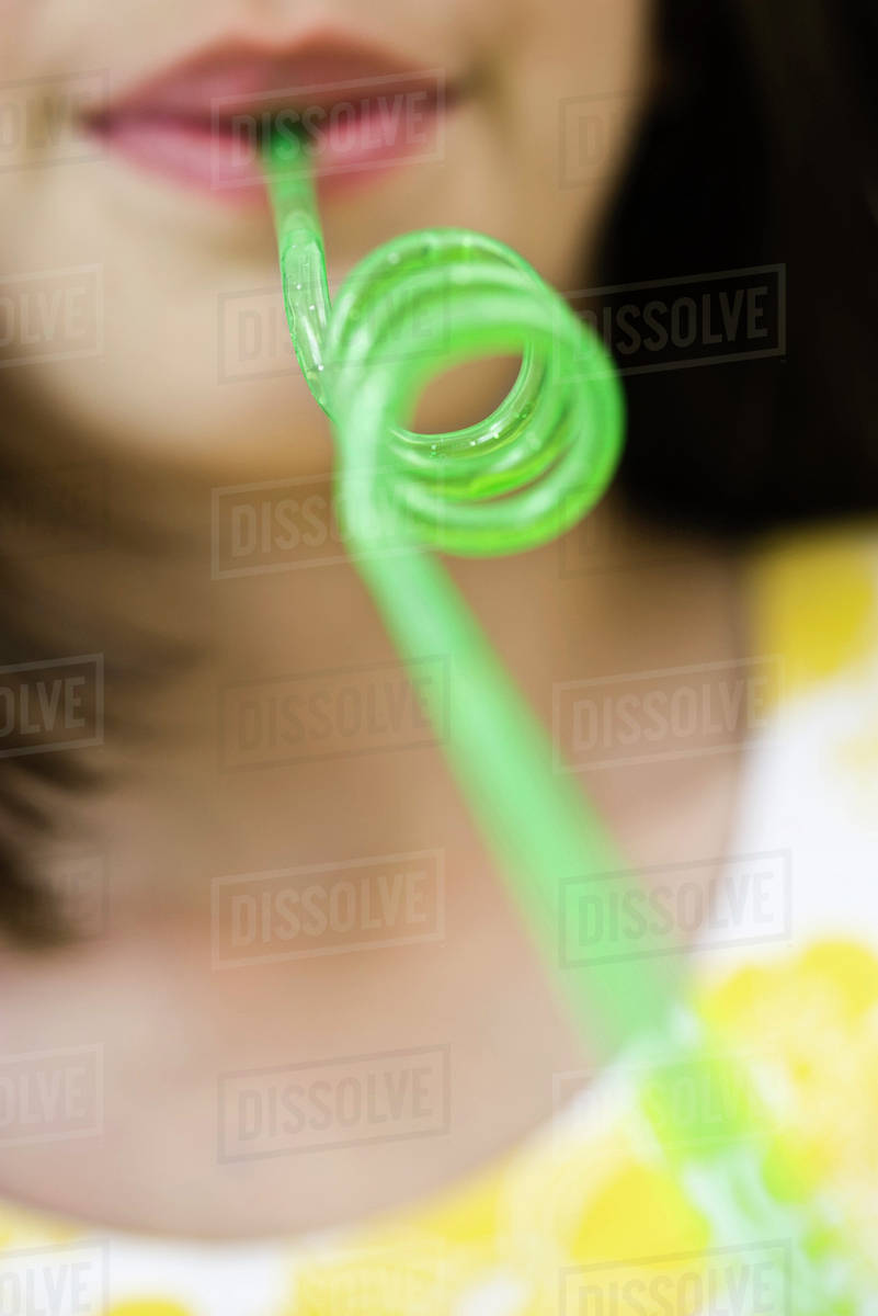 Drinking through curly straw Stock Photo Dissolve
