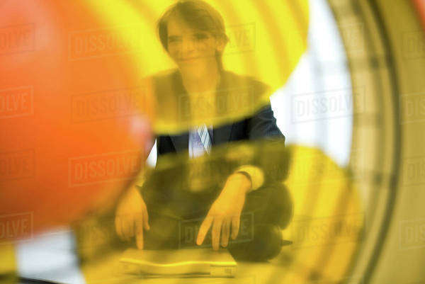 Young man sitting with laptop computer, looking at camera, viewed ...