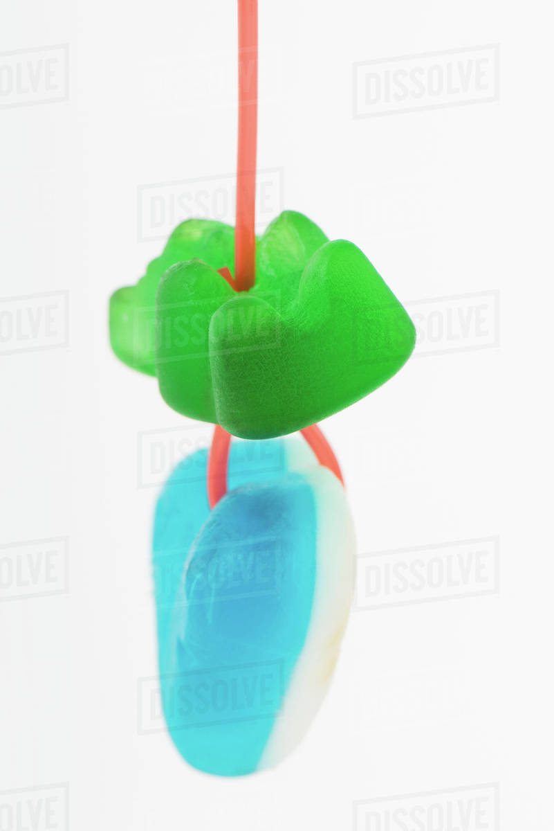 Candy hanging from string, closeup Stock Photo Dissolve