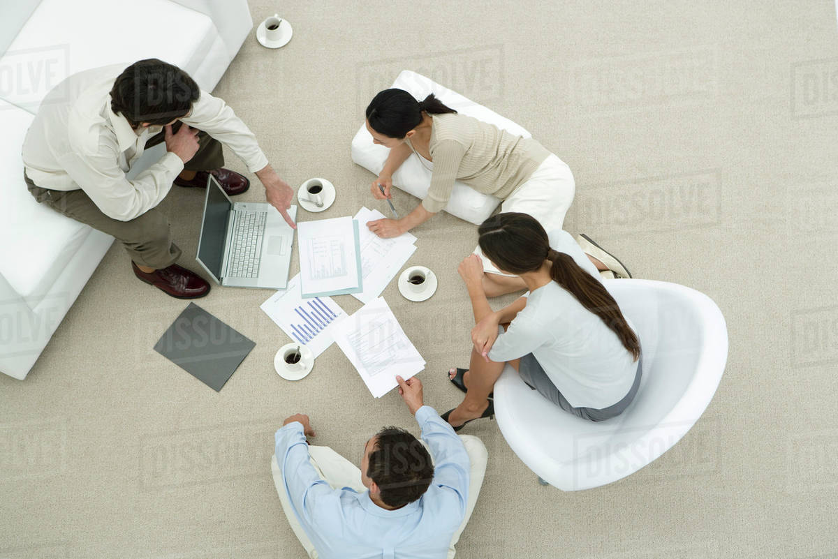 Team of professionals in casual work environment, discussing documents