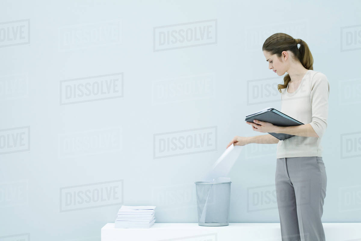 Professional woman throwing away document, holding folder Stock Photo