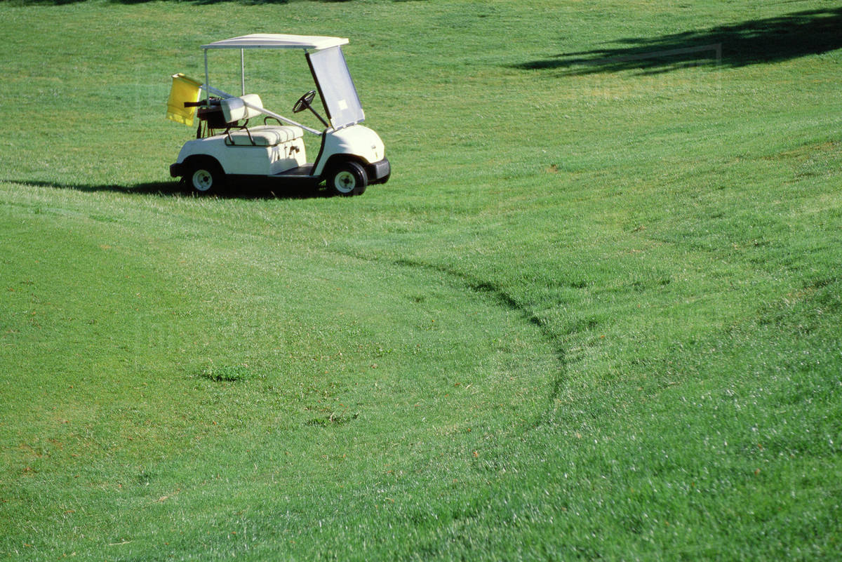 Golf cart parked on golf course Stock Photo Dissolve