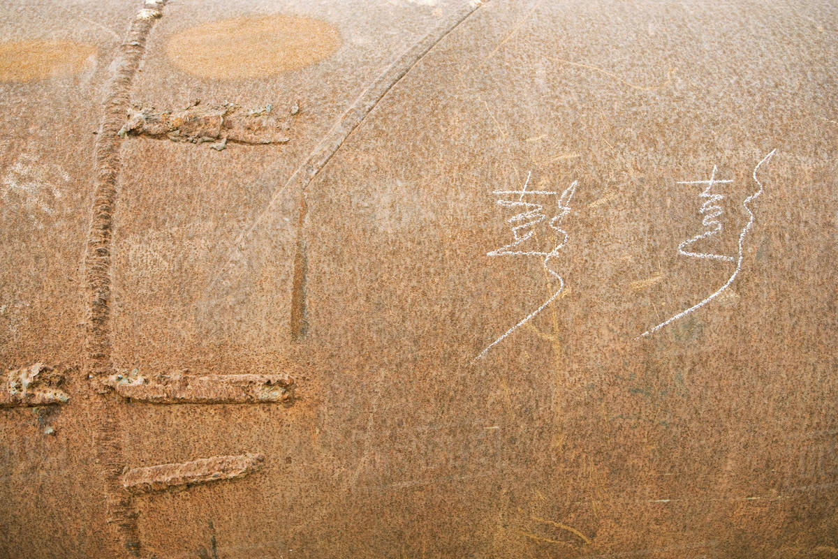 Metal surface with Chinese characters handwritten in chalk Stock