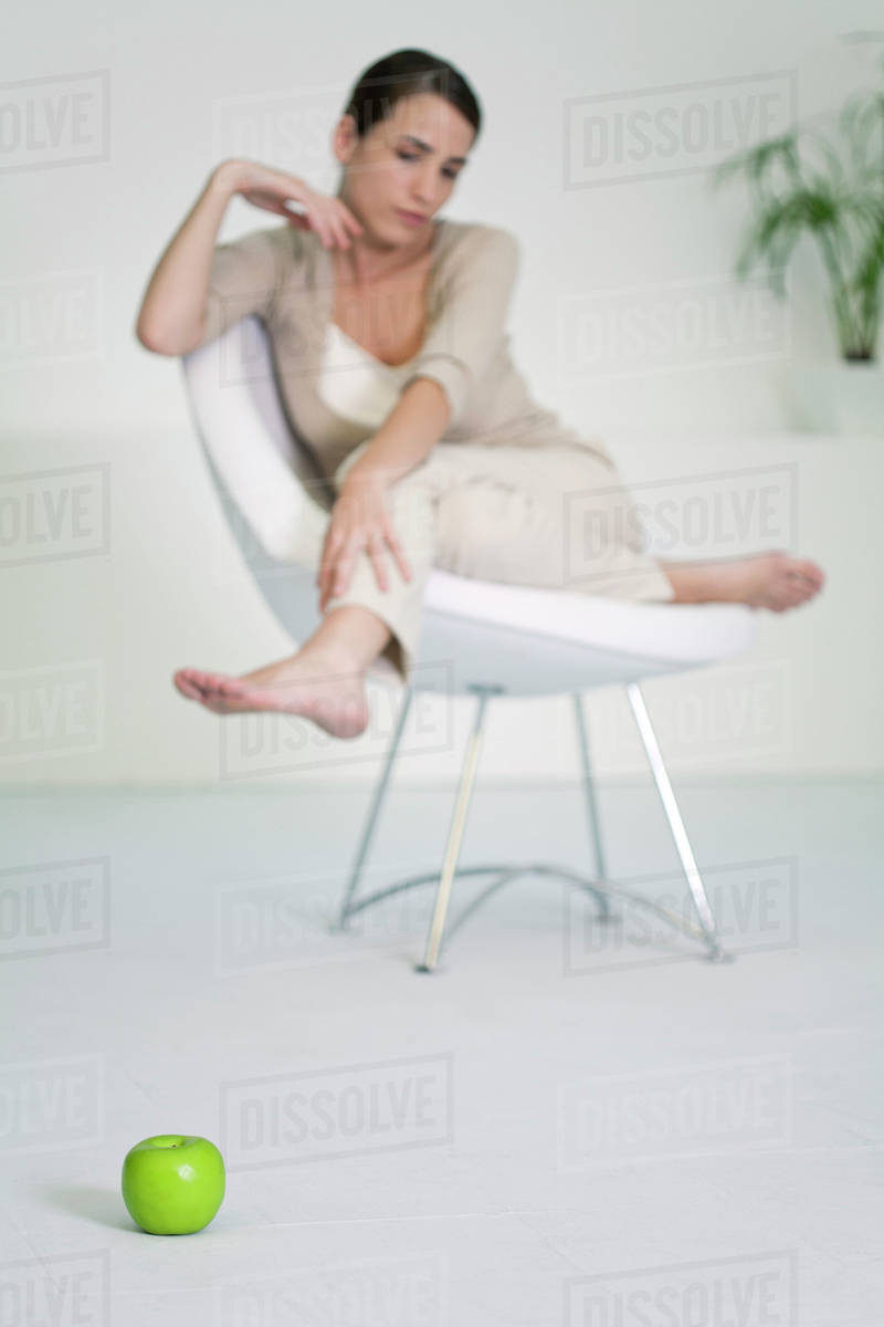 Woman Relaxing In Chair Looking At Le On Floor Foreground Woman Relaxing In Chair Looking At Le On Floor Foreground