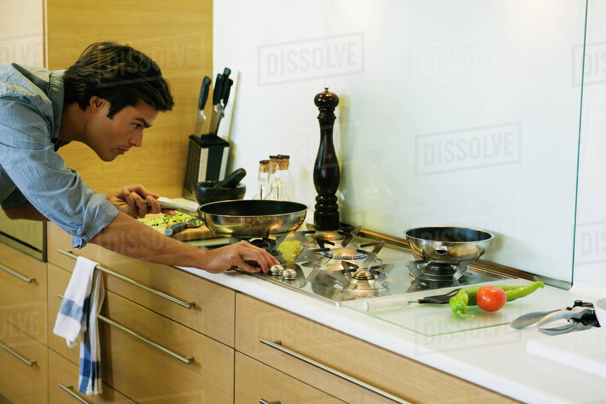 Man cooking on gas stovetop Stock Photo Dissolve