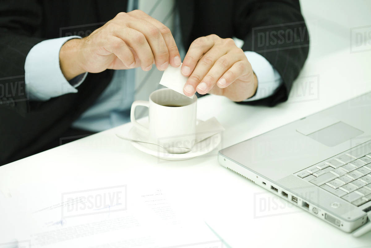 Professional man preparing coffee at desk, cropped view Stock Photo