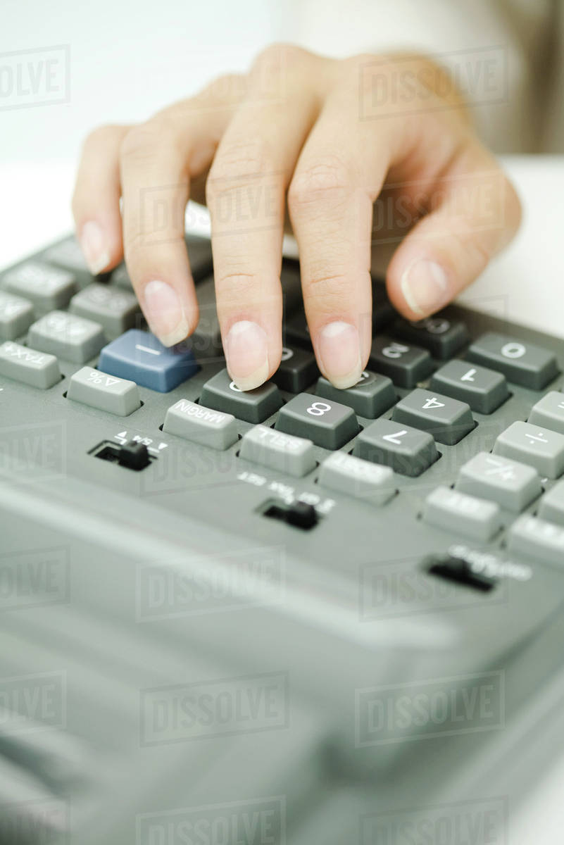 Woman's hand using adding machine, close-up - Stock Photo - Dissolve