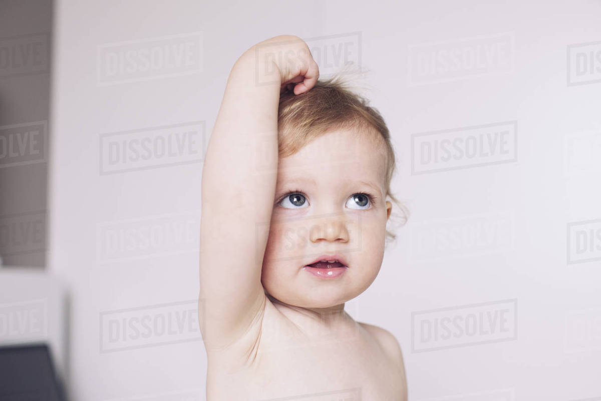 Baby putting hand on head Stock Photo Dissolve