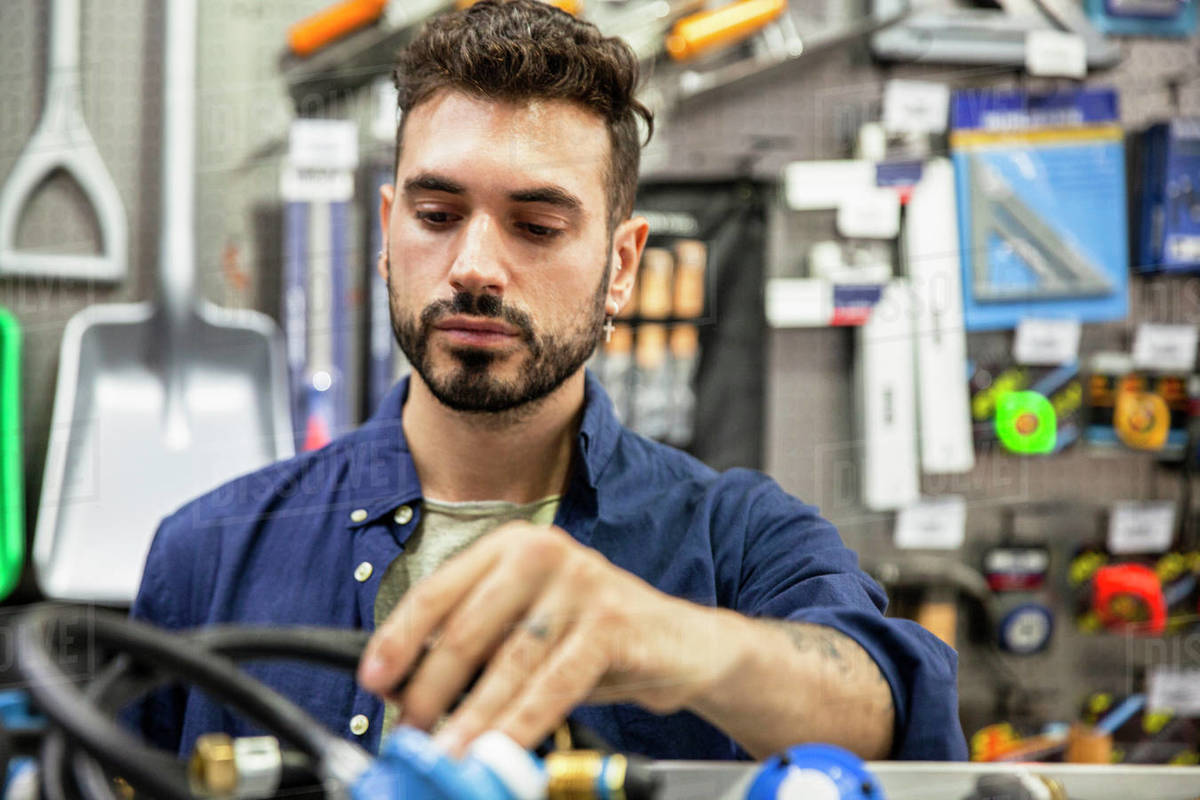 Male hardware shop owner sorting out products Stock Photo Dissolve