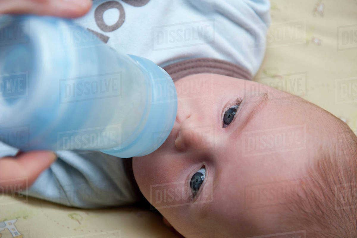 Baby drinking from baby bottle Stock Photo Dissolve