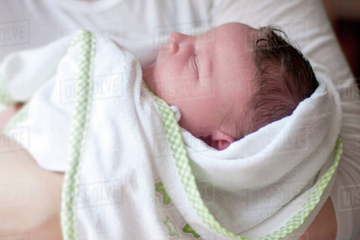 Sleeping new born baby swaddled in blanket Stock Photo Dissolve