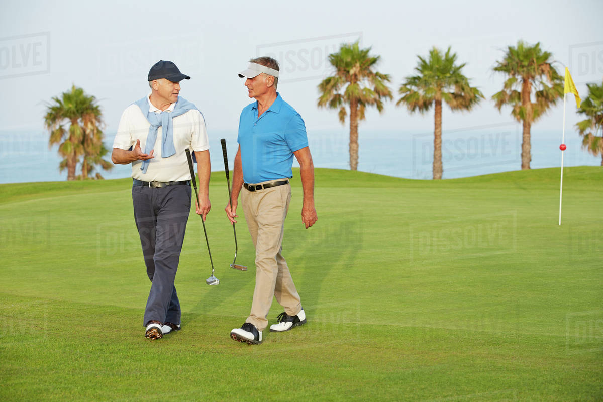 Senior men walking on golf course Stock Photo Dissolve