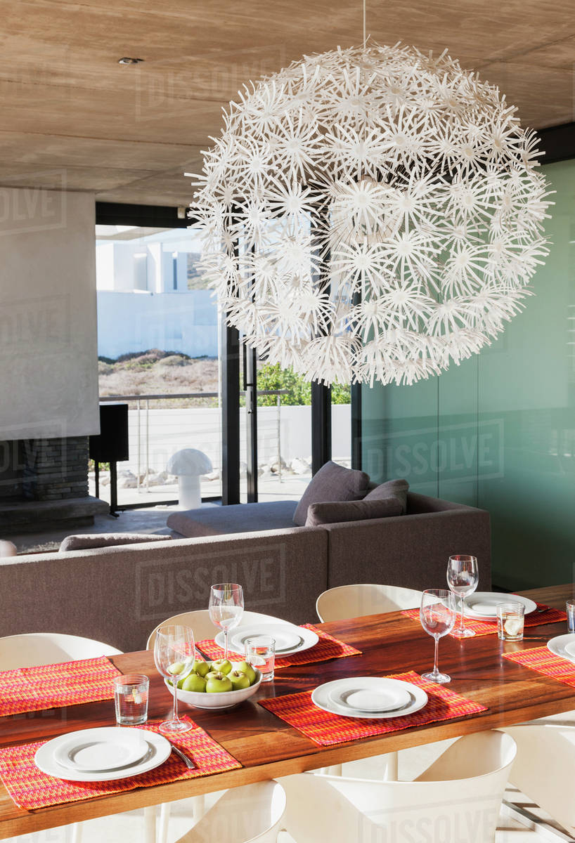 Chandelier over set dining table in modern dining room Stock Photo