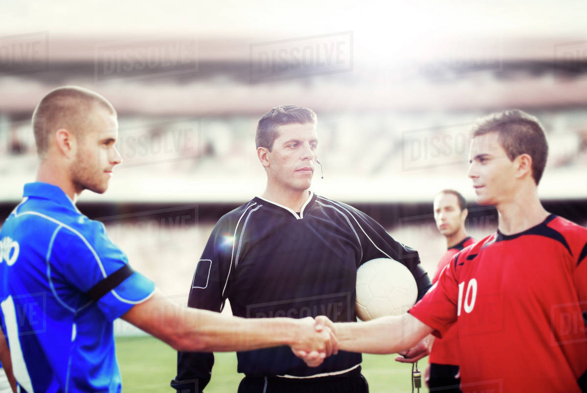 Soccer players shaking hands on field Stock Photo Dissolve
