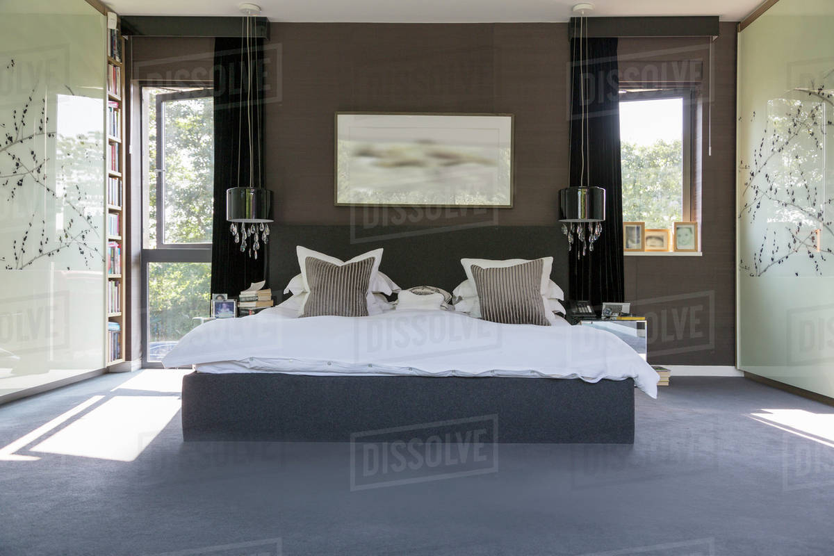 Lamps and wall art in modern bedroom Stock Photo Dissolve