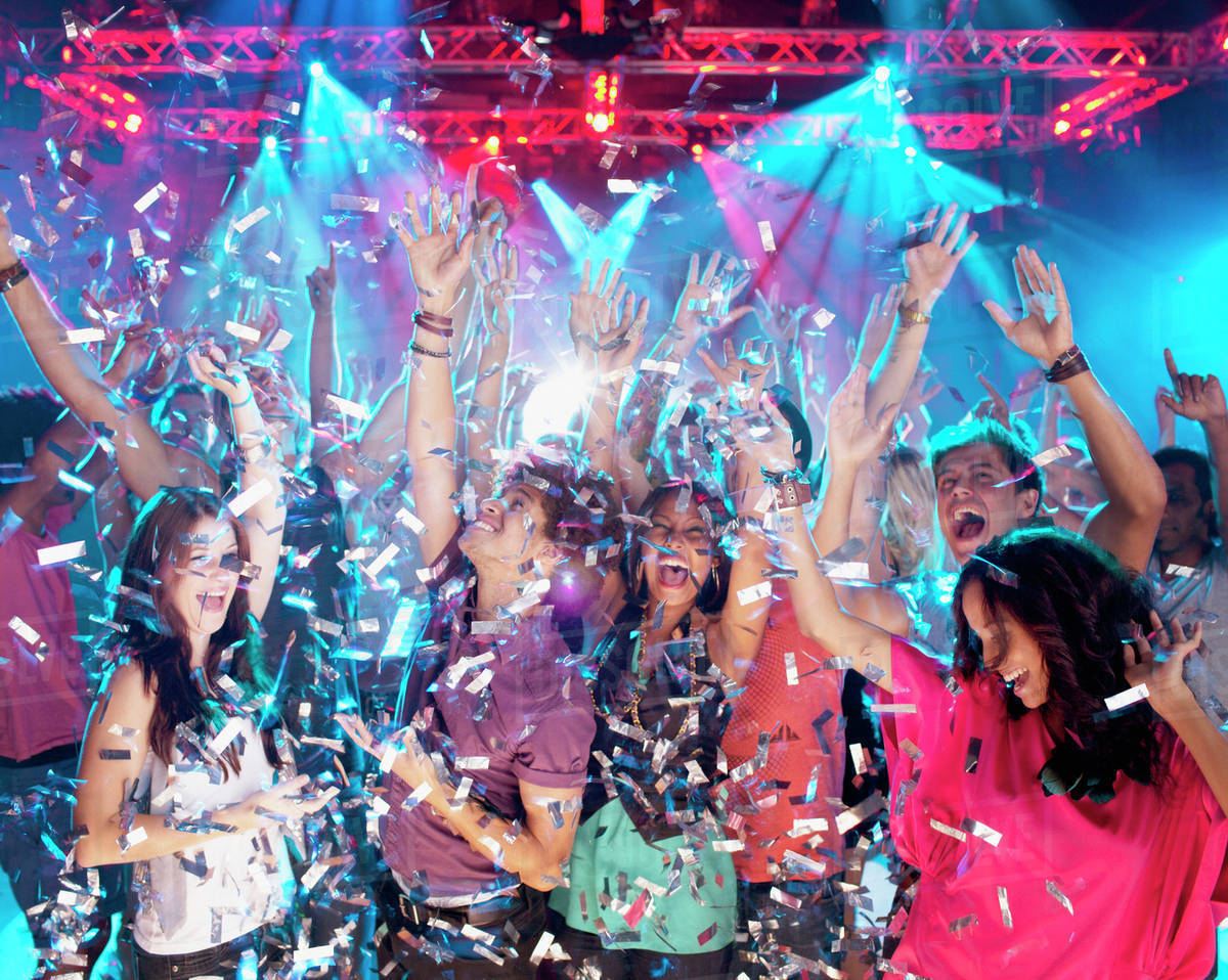 Confetti falling over enthusiastic crowd on dance floor of