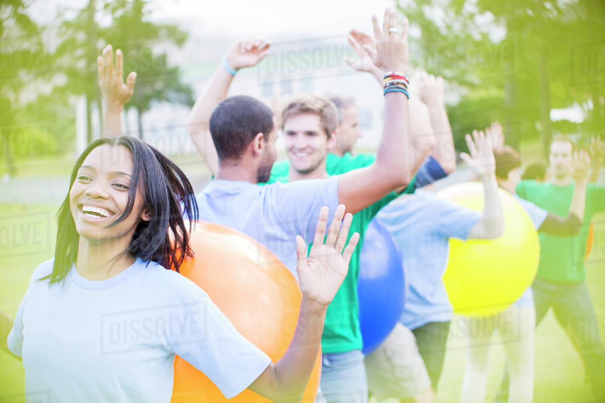 Teammates performing fitness ball team building activity Stock Photo