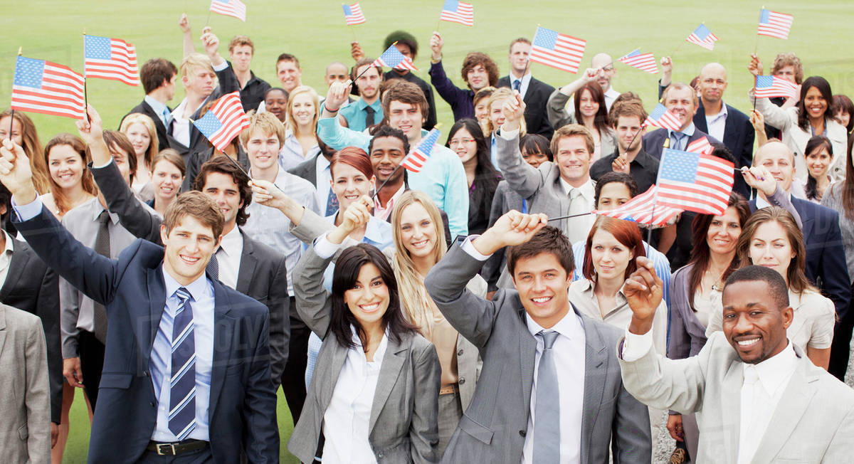 Portrait of smiling business people waving American flags overhead