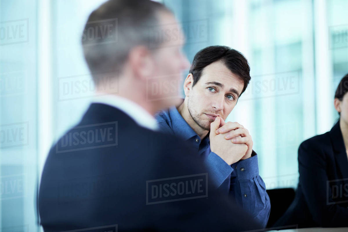 Attentive serious businessman listening to colleague in meeting - Stock ...
