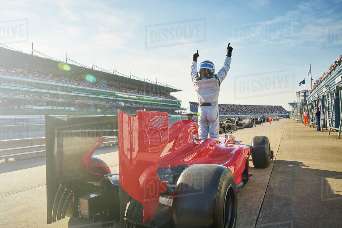 Formula one race car driver cheering on sports track, celebrating victory Royalty-free stock photo