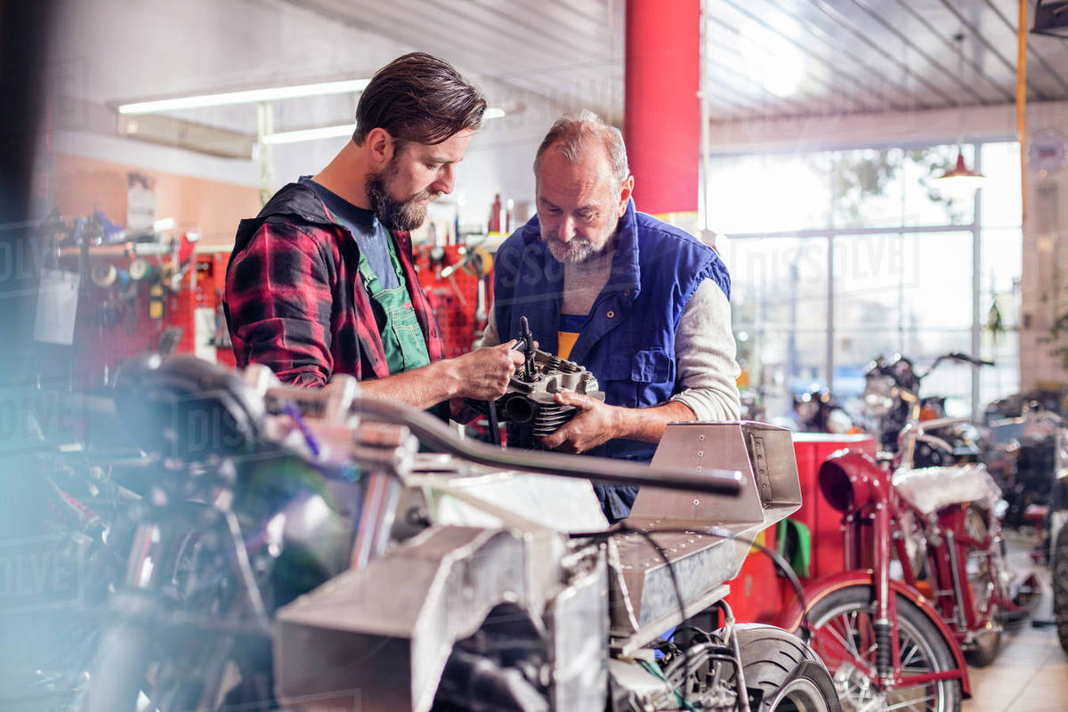 Male motorcycle mechanics repairing part in Stock Photo