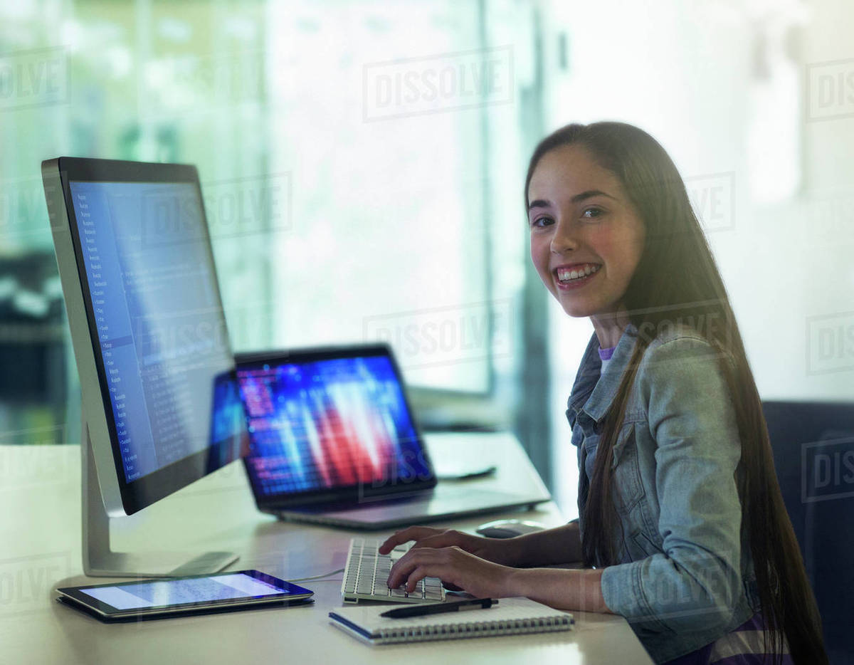 Portrait smiling, confident girl student programming at computer in ...