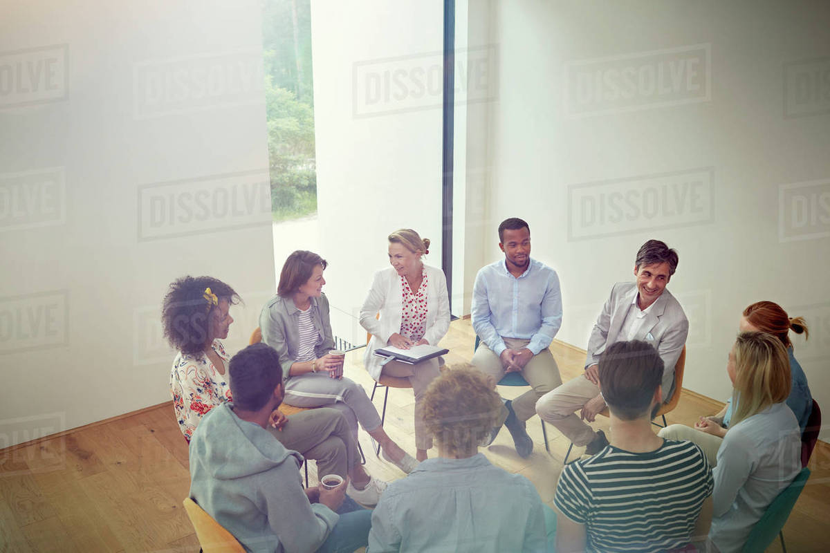 People talking in a circle in group therapy session Stock Photo
