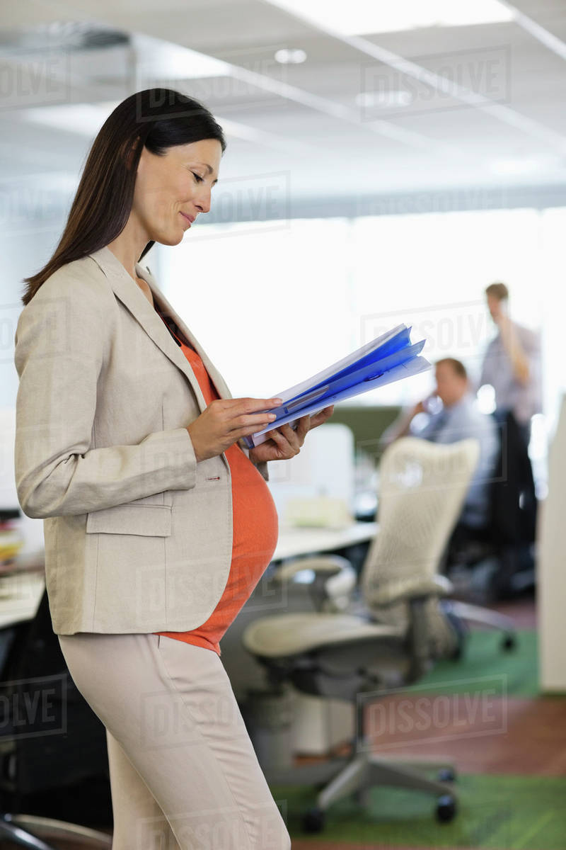 Pregnant businesswoman working in office Stock Photo Dissolve