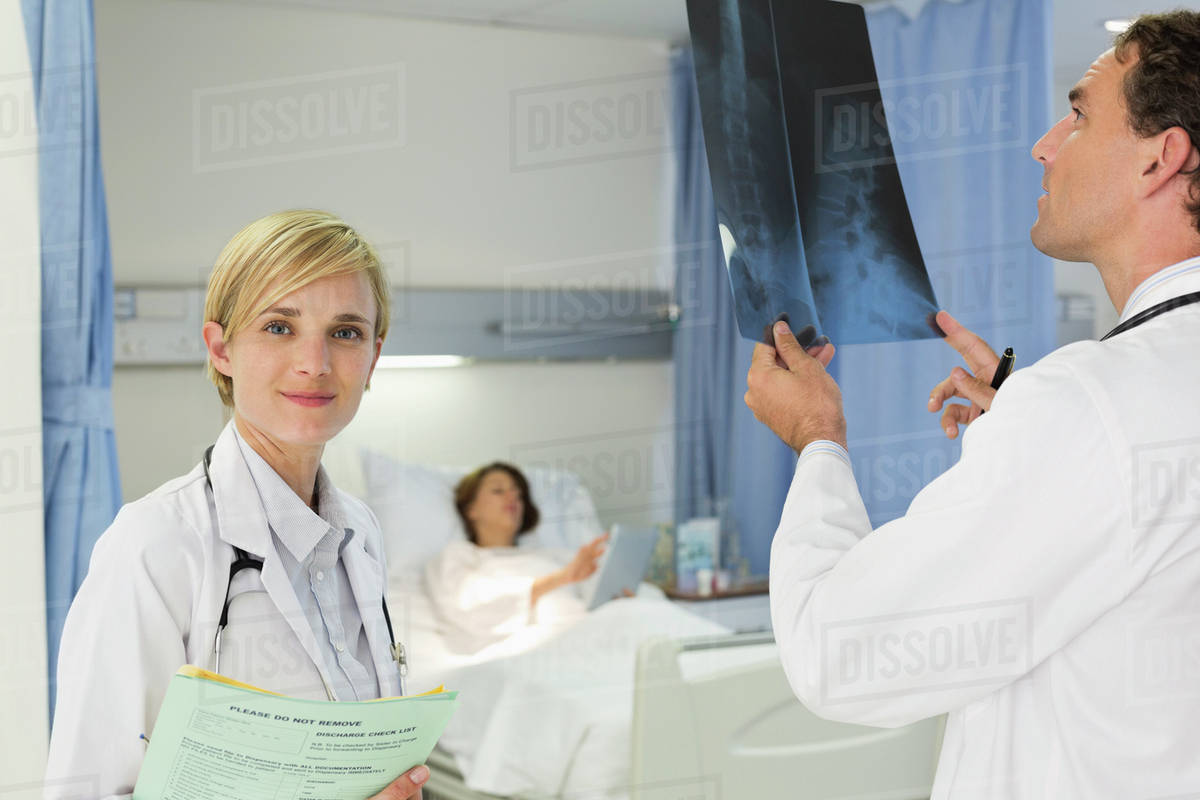 Doctors examining xrays in hospital room Stock Photo Dissolve