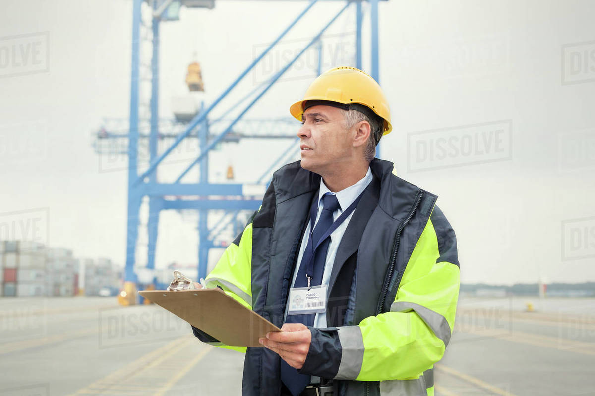 Dock manager with clipboard at shipyard Stock Photo Dissolve