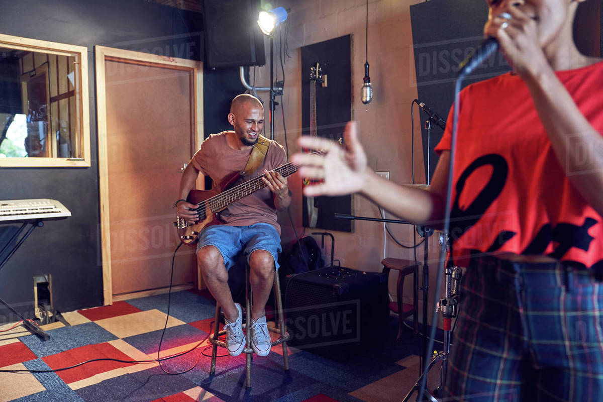 Musicians singing and playing guitar in recording studio Stock Photo