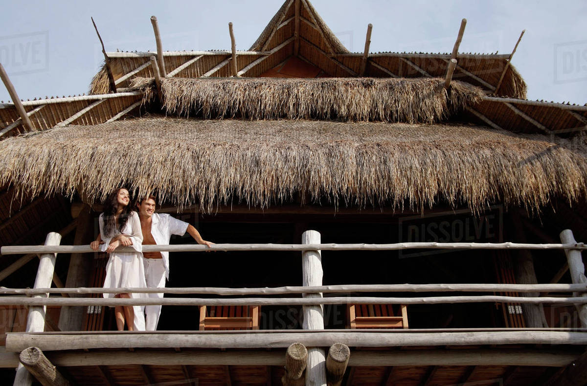 Couple looking off balcony Stock Photo Dissolve