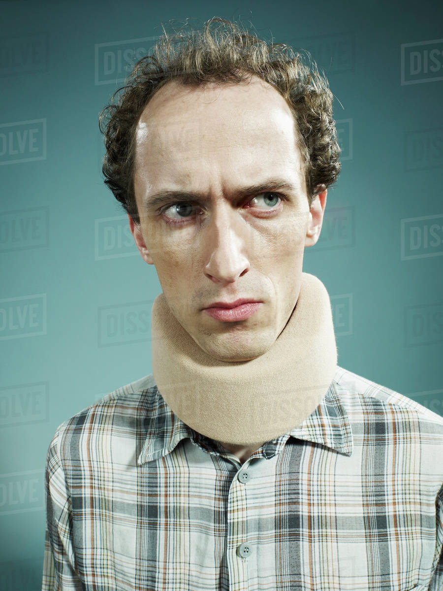 A Displeased Man Wearing Neck Brace And Looking Suiously To A Displeased Man Wearing Neck Brace And Looking Suiously To The Side