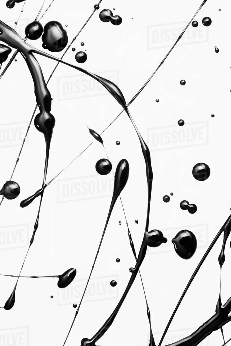 Black paint splattered on a white surface making an elegant pattern