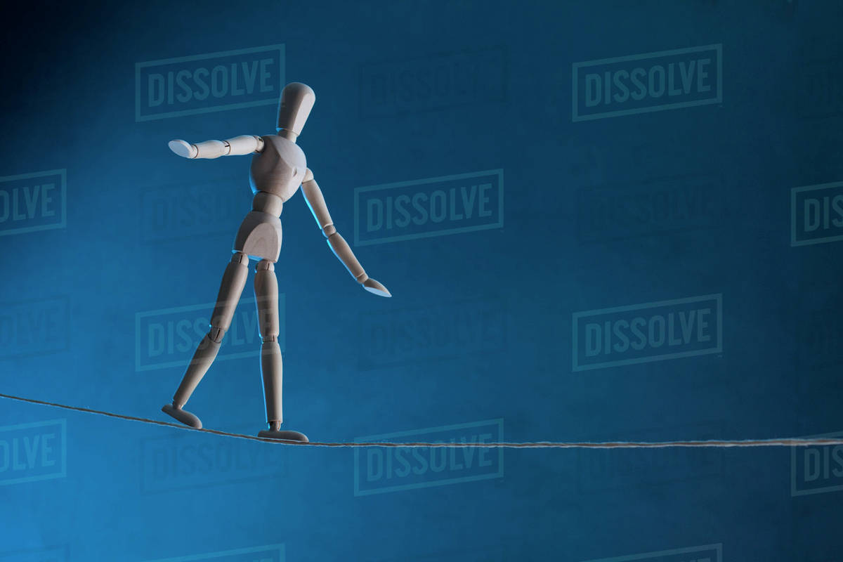 An artist's figure walking a tightrope - Stock Photo - Dissolve