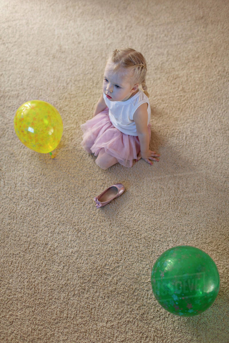 Little girl between two balloons as her ballet shoe lies on the floor Stock Photo Dissolve