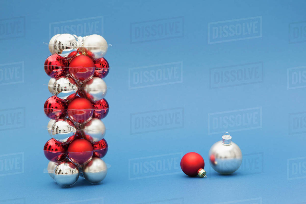 stack of red and silver colored christmas ornaments on blue background - Red And Silver Christmas Ornaments stack of red and silver colored christmas ornaments on blue background - Red And Silver Christmas Ornaments