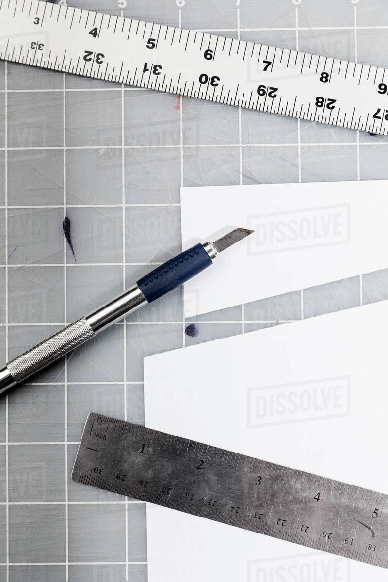 Cutter and rulers on cutting mat Stock Photo Dissolve