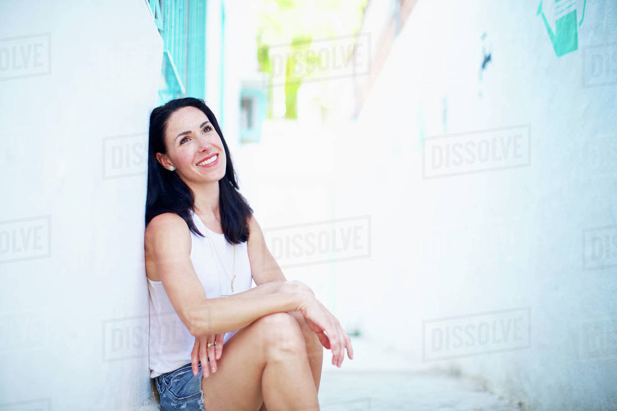 Portrait smiling, confident woman relaxing in summer alley Royalty-free stock photo