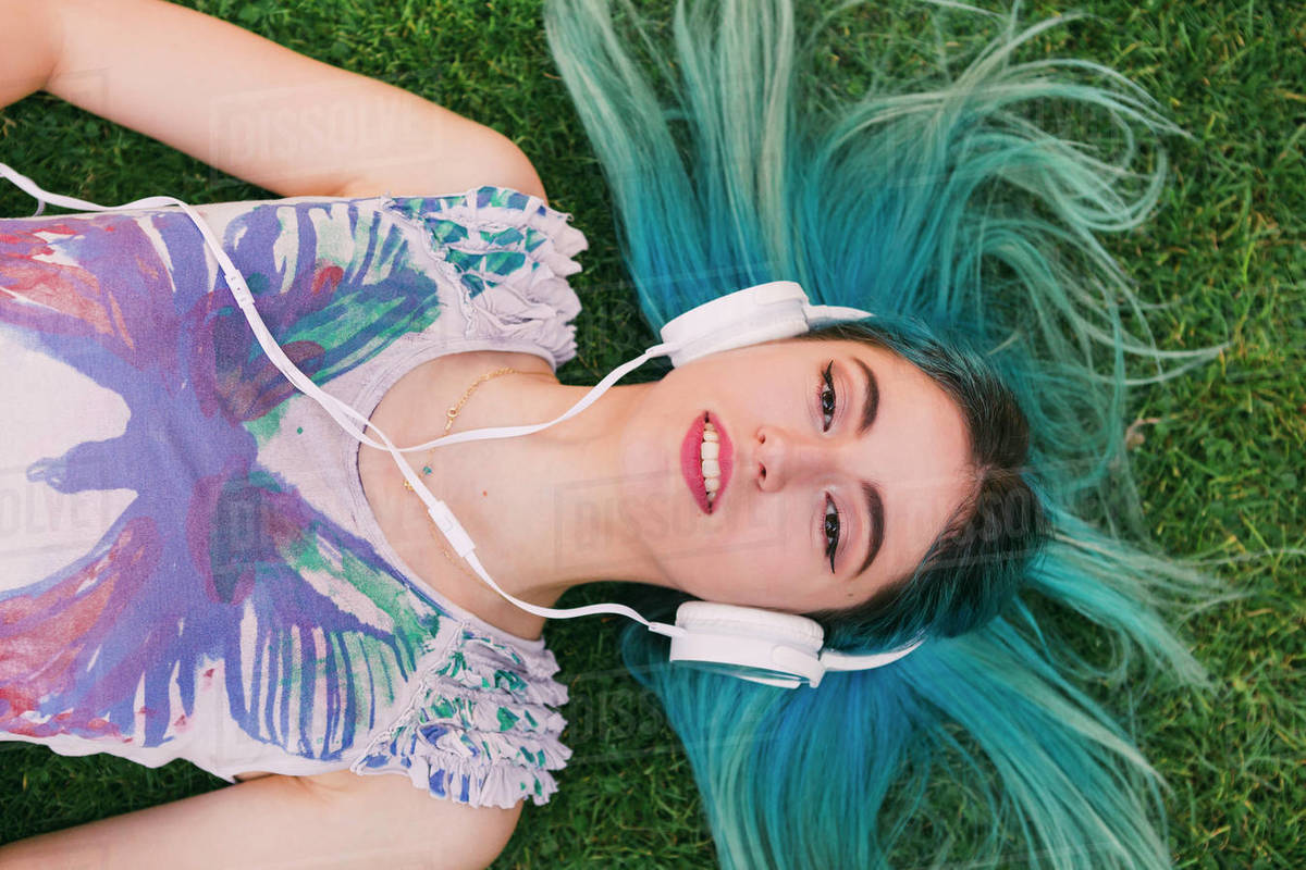 Overhead portrait young woman with blue hair listening to music with headphones Royalty-free stock photo