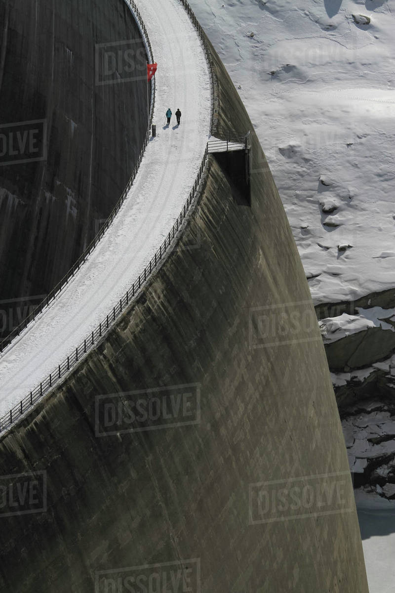 People walking across snow covered dam, Vals, Canton of Grisons, Switzerland Royalty-free stock photo