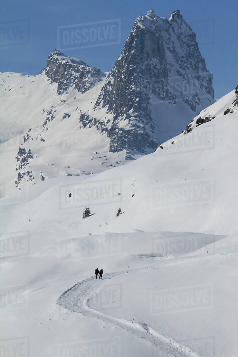 People snowshoeing on sunny, snow covered mountain, Vals, Canton of Grisons, Switzerland Royalty-free stock photo